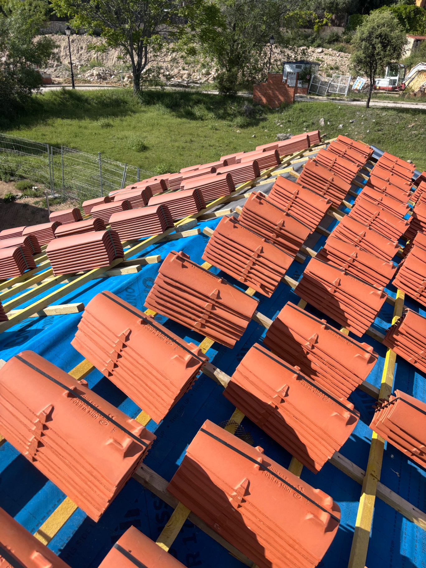 Cubierta en obra con tejas apiladas listas para su colocación